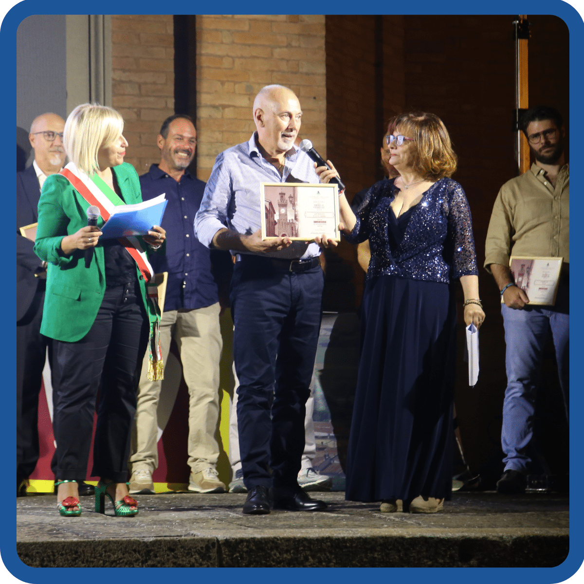 Angiolino Coccaro premiato con il riconoscimento di Azienda storica di Castel San Pietro Terme per la sua bottega di calzolaio "all'istante". Con lui nella foto la sindaca Francesca Marchetti e la presentatrice della serata Giorgia Bottazzi, durante Castello in DVD del Settembre castellano